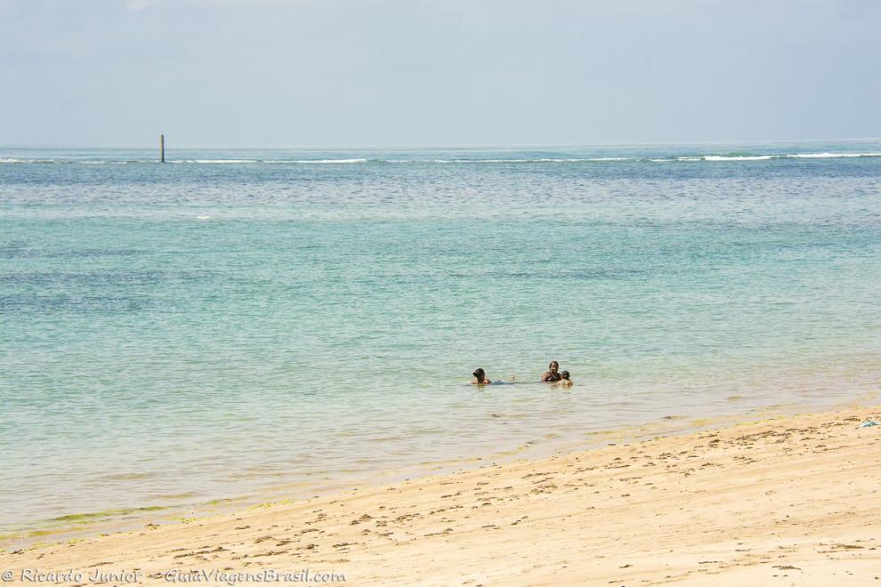 Imagem de uma família deitados na beira da Ilha de Itaparica.